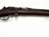 un vieux fusil accroché au mur d'une pièce