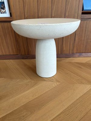 a small white table on the floor in a room