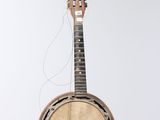 an old banjo is hanging from a string on a white wall