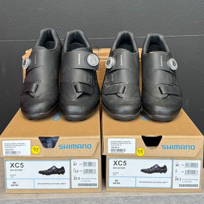 trois paires de chaussures Shimano posées sur une boîte