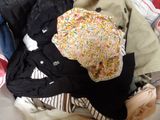 un tas de vêtements et un chapeau posés sur un lit