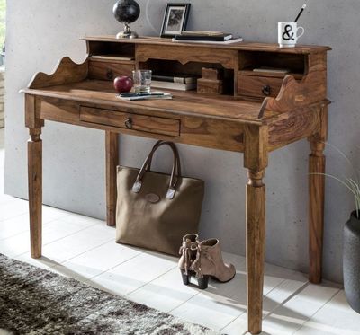 un bureau en bois sur lequel est posé un sac, avec un miroir au-dessus