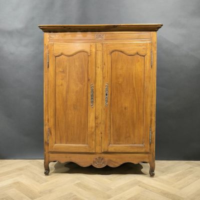 une armoire en bois à deux portes, surmontée d'un tiroir