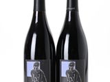 deux bouteilles de vin rouge posées l'une à côté de l'autre sur une surface blanche