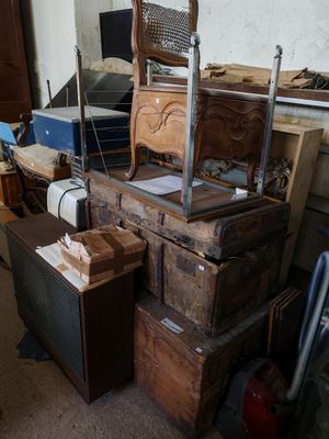 une pile de cartons et une chaise dans un coin de la pièce