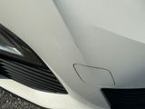 a close up of a car ' s front bumper on the street