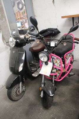 two mopeds parked next to each other in a garage