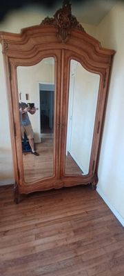 une personne en train de prendre une photo d'un miroir dans une pièce
