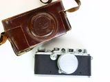 a brown camera and a brown camera case on a white table