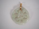 une photo d'un pendentif en jade blanc muni d'un fermoir en or