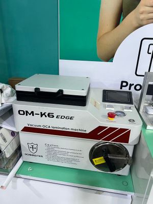 a woman standing next to a machine that is sitting on a table