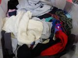 a basket full of clothes that is sitting on the floor