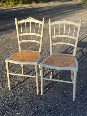 two chairs sitting next to each other on a gravel road