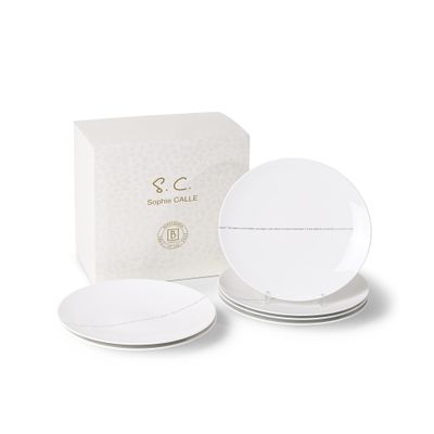 three white plates and a box of white paper on a white surface