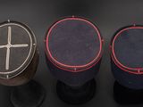 three different colored boxes with a cross on them on a black surface
