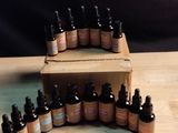 many bottles of essential oils sitting on a wooden table