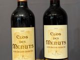 two bottles of wine sitting on top of a wooden table