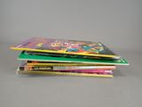 several children ' s books stacked on top of each other on a table