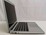 a laptop computer sitting on a table with a white curtain in the background
