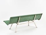a green bench that is sitting on a white surface