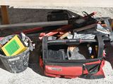 a red tool bag sitting on the ground next to a table