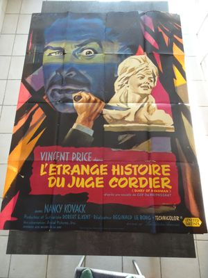 affiche de cinéma représentant un homme tenant un couteau devant une grande affiche représentant un homme