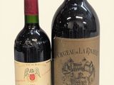 two bottles of wine sitting next to each other on a white surface