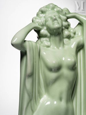 a green statue of a woman holding her hands on her head