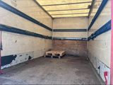 une photo d'un local de stockage avec une palette en bois posée au sol