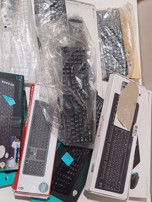 many different types of keyboards and remotes sitting on a table