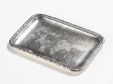 rectangular silver plate with beaded edge on white surface
