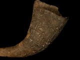 a large horn with carvings on it on a black background