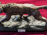 a bronze statue of a dog on a rock