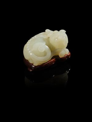 une sculpture en jade blanc représentant un chat, posée sur une surface noire