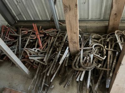 un tas de vieux fers à cheval et d'autres outils dans une remise