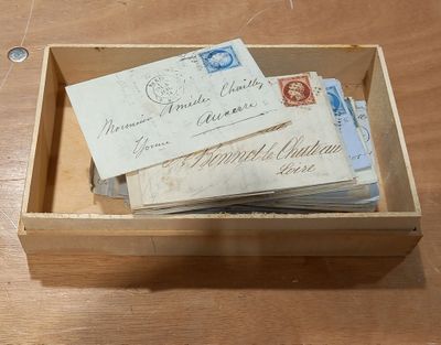 une boîte en bois remplie de vieilles enveloppes posée sur une table