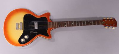 an orange and black electric guitar sitting on top of a white surface