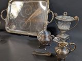 a silver tray with a mirror and silverware on it
