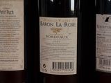 three bottles of wine are lined up on a shelf in a store