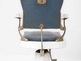 a blue and white barber chair with a brown handle