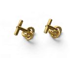 a pair of gold cufflinks on a white background