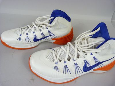 une paire de baskets blanches et bleues avec des semelles orange sur un fond blanc