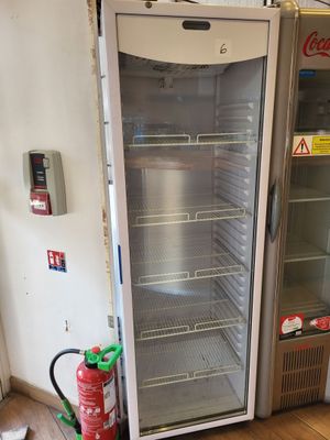 un réfrigérateur à côté duquel se trouve un extincteur