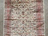 un tapis persan ancien avec un motif floral et des franges