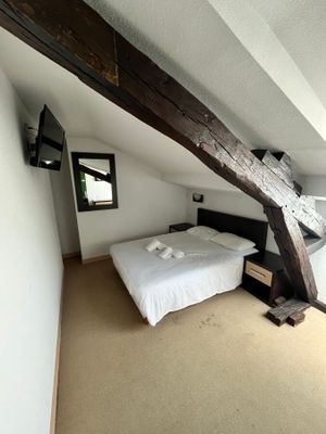 une chambre avec un lit et une télévision accrochée au mur