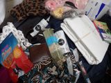 a pile of clothes and other items on a bed