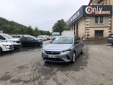 the grey car is parked in front of a building with cars parked in front of it