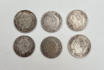 six types différents de pièces d'argent posées sur une surface blanche