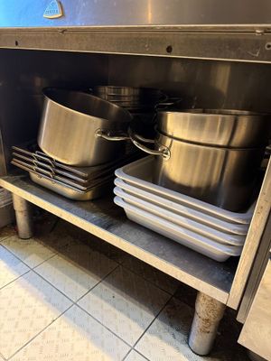 de nombreuses casseroles et poêles sur l'étagère de la cuisine