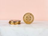 a gold coin sitting next to a stack of gold coins
